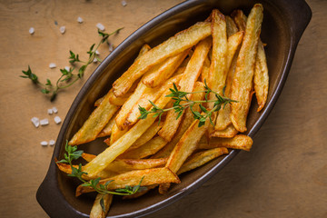 Potatoes fries in the bowl with salt and thyme