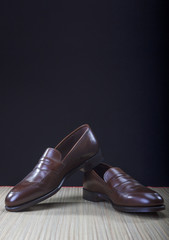 Mens Brown Penny Loafer Shoes Against Black Background