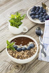 Chocolate Banana Smoothies Bowl with a topping of granola, blueberries, white sesame