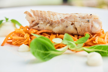 Dinner of Pollock in the marinade, served on a white plate