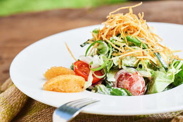 Healthy salad of pike caviar and vegetables served on white plate