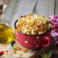 Homemade pasta. Traditional Italian in the form of hearts in a red ceramic pot before cooking