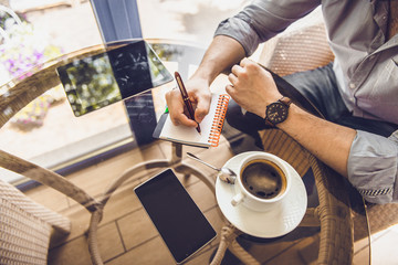 Businessman in a cafe drinking coffee and working on a Tablet PC