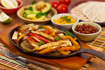 Chicken Fajitas with Grilled Onions and Bell Peppers serve with Tortillas. Selective focus.