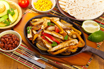 Chicken Fajitas with Grilled Onions and Bell Peppers serve with Tortillas. Selective focus.