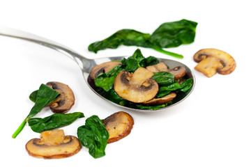 Sauteed Mushrooms and Spinach on White. Selective focus.