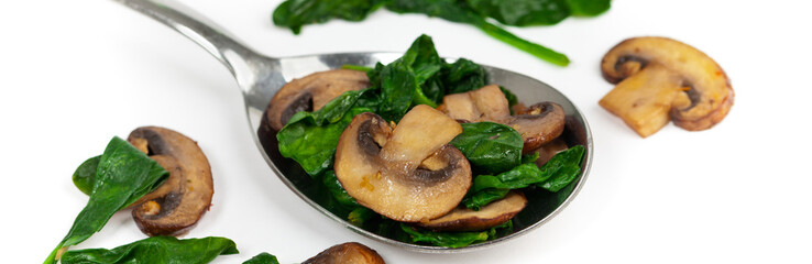 Sauteed Mushrooms and Spinach on White. Selective focus.