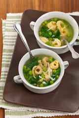 Tortellini Soup with Peas and Spinach. Selective focus.