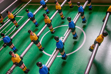 Table football game.Table football in a close up macro with blue and yellow figures.