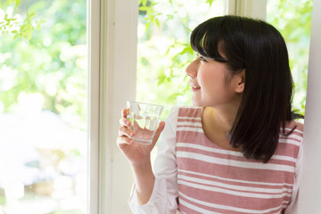 部屋で水を飲む女性