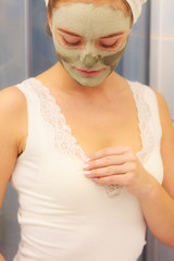 Woman face with green clay mud mask