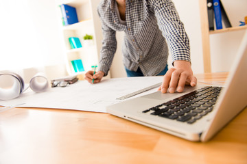 Close up photo of man using laptop to draw scheme