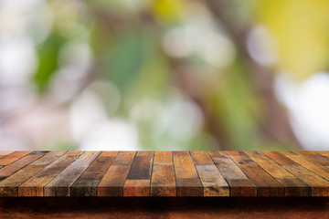 Empty wooden table with  blurred green background.