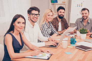 photo of  young  team sitting at conference table and smiling