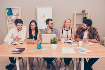 photo of  happy young  team sitting at conference table talking