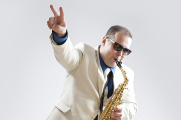 Fototapeta premium Music Concepts and Ideas. Portrait of Hadnsome Male Saxophone Playing and Showing V sign