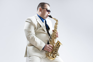 Fototapeta premium Portrait of Expressive Stylish Caucasian Saxophone Player Performing in Studio Environment