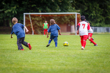Boys playing soccer with goalkeeper in the background