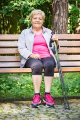 Naklejka na ściany i meble Senior woman resting after nordic walking, sporty lifestyles in old age