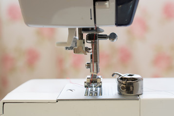 Red needle placed in a white sewing machine