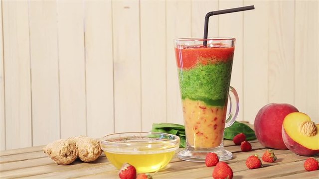 Tasty smoothies for breakfast with peach, mango, spinach, yogurt, strawberry and honey. Summer smoothie with fresh bright juicy organic fruit rotation on wooden vintage background