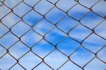 Fototapeta premium iron wire fence on blue sky background