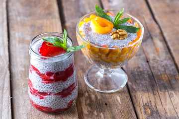 Raw vegan desserts: Chia seeds pudding with fruits on a wooden background
