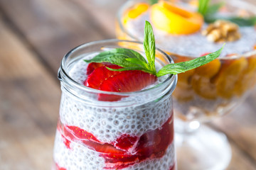 Raw vegan desserts: Chia seeds pudding with fruits on a wooden background
