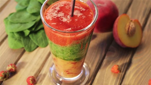 Top view of Tasty smoothies for breakfast with peach, mango, spinach, yogurt, strawberry and honey. Summer smoothie with fresh bright juicy organic fruit rotation on wooden vintage background
