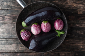 Eggplants sprinkled with water on large frying pan. Top view with copy space