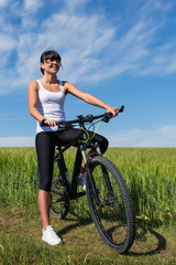 Fototapeta na wymiar woman going for bike ride on sunny day in countryside
