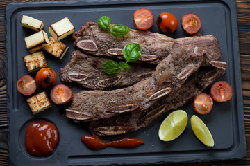 Barbecued beef ribs with cheese and cherry tomatoes, top view