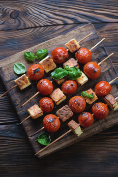 Cherry tomatoes and cheese skewers in a rustic wooden setting