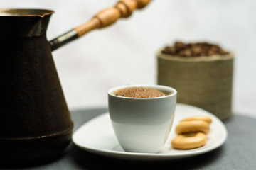 Cup of coffee, a Turk and grains on gray background