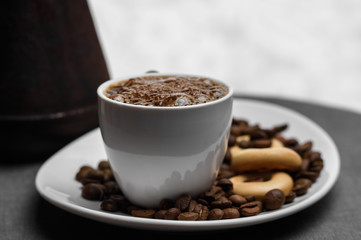 Cup of coffee, a Turk and grains on gray background