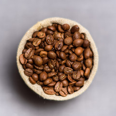 coffee beans in flax sack on grey background