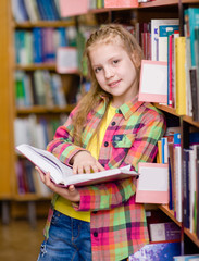 Teen girl reading a book in the library