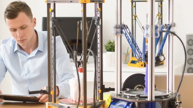 Serious man working with 3d printer