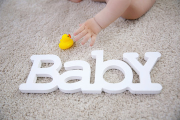 Baby and decorative word on the floor