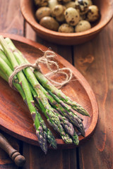 Asparagus with quail eggs, on rustic wooden background