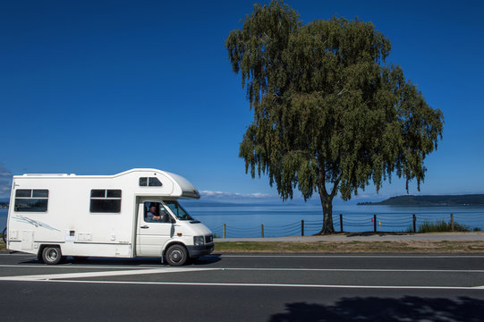 A motorhome driving along the coast of Lake Taupo in North Island of New Zealand