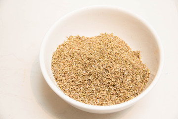 Dried rosemary in small white bowl