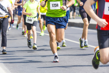 marathon runners with their shadows running on the street