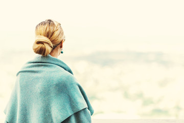 Back view of a woman with tied blond hair..