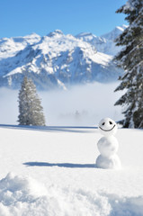 Obraz na płótnie Canvas Snowman against Alpine scenery