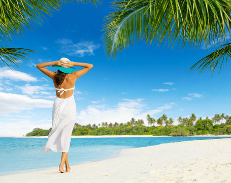 Beautiful girl walking on tropical beach