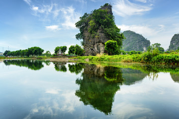 Scenic natural karst tower reflected in water, Vietnam