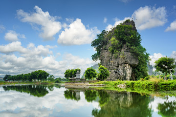 Fototapeta na wymiar Scenic karst tower reflected in water of the Ngo Dong River
