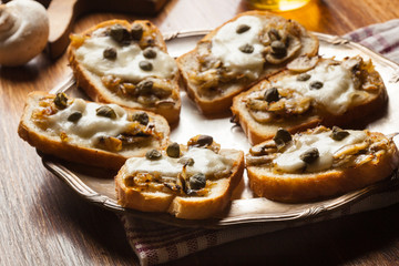 Crostini with fried mushrooms, onion and mozzarella cheese