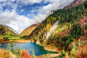 Fototapeten The Upper Seasonal Lake among colorful fall woods and mountains © efired